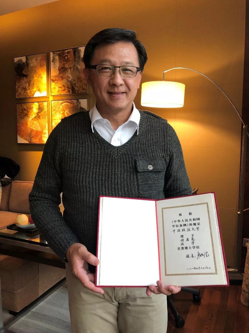 △何君尧展示名誉博士学位证书