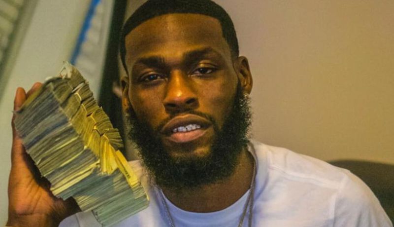 亨德森手持大量现金的照片(图片来源：纽约“每日新闻”)