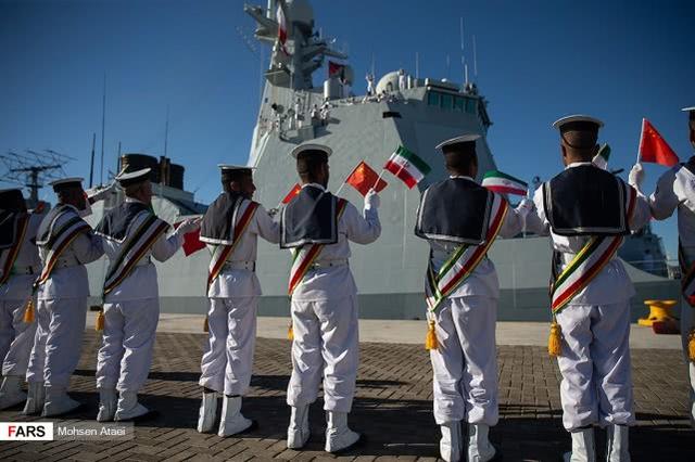 图为在恰巴哈尔港举行的欢迎仪式上挥舞中国和伊朗两国国旗的伊朗海军士兵。
