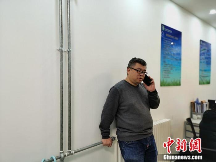 刘源在手术前做最后的沟通，这些年，他的手机一直是24小时开机。中新网记者 张尼 摄
