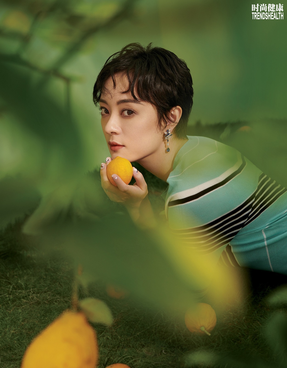 照片中,孙俪或身着一袭水蓝色条纹针织长裙,置身草木果树间,复古妩媚