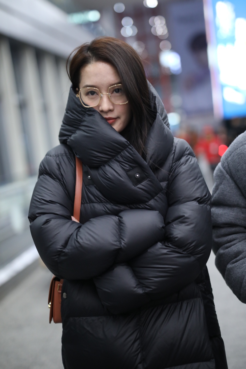 李沁穿黑色羽绒服认真保暖 戴金色边框眼镜飒爽有魅力