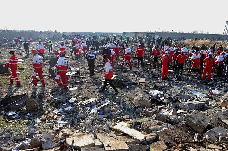 1月8日，在伊朗德黑兰霍梅尼国际机场附近，救援人员在坠机现场工作。 新华社 图