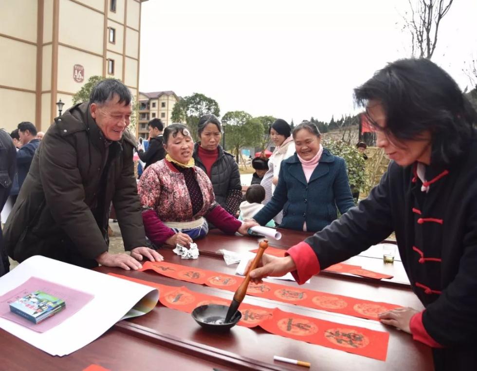 2020年1月11日，志愿者在易地扶贫搬迁安置点为居民写春联。新华社记者 骆飞 摄
