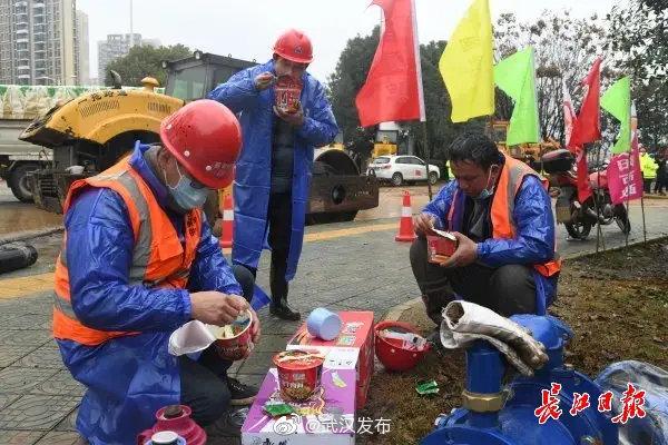 在武汉小汤山模式医院建设现场，一群施工者们正在吃着方便面做午餐。记者詹松 摄