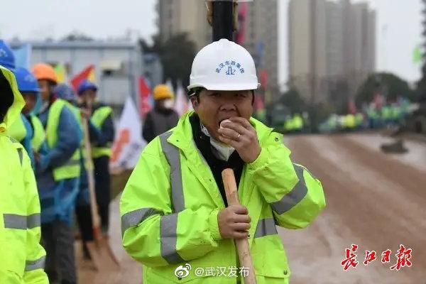 在武汉小汤山模式医院施工现场，一名施工者正在吃着刚刚送来的包子做午餐。记者詹松 摄