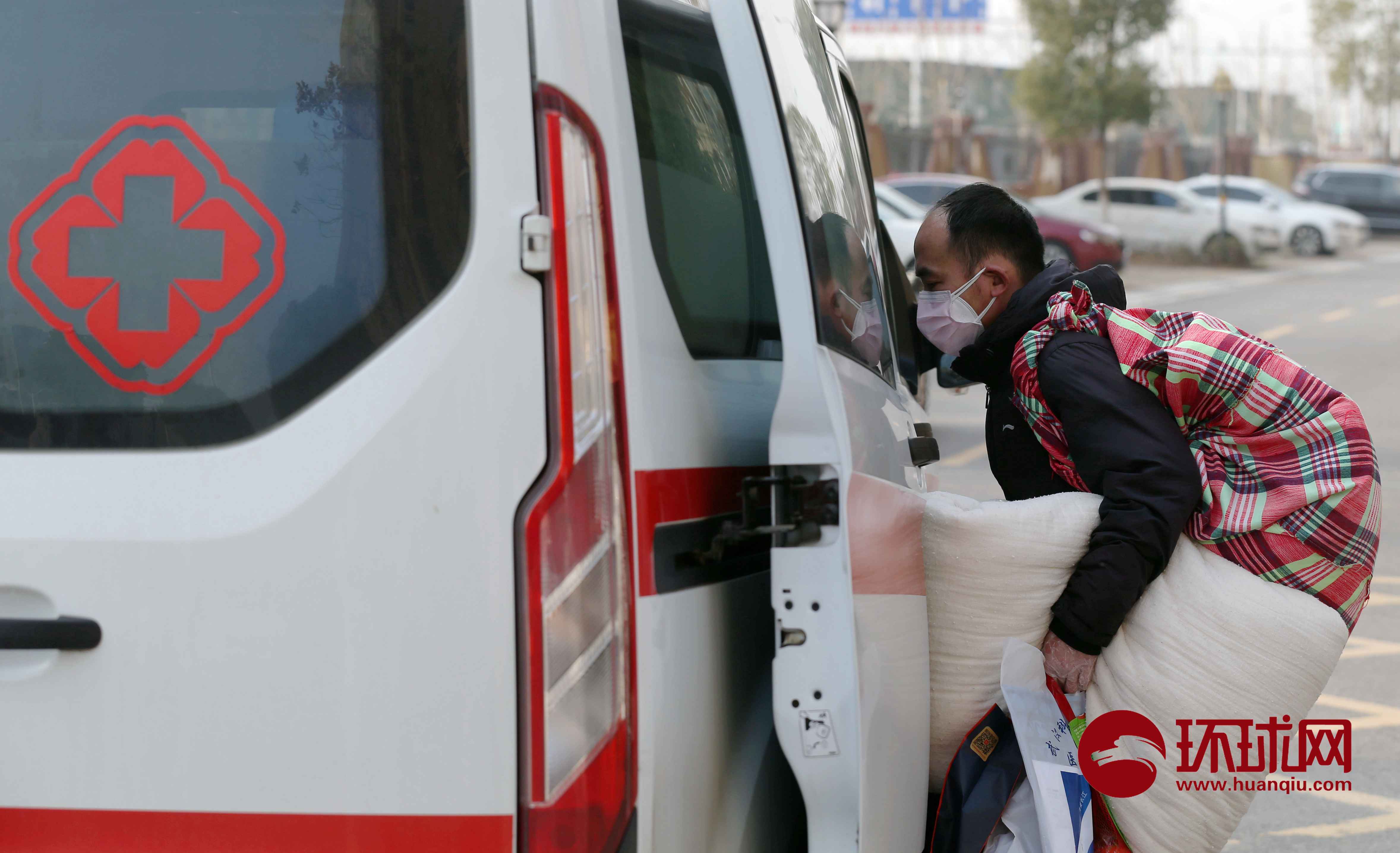 一名疑似患者携带生活用品自行登上急救车前往社区集中隔离点。