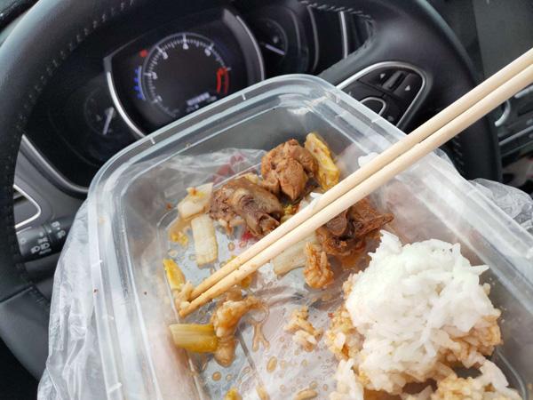 志愿者在车上吃盒饭.