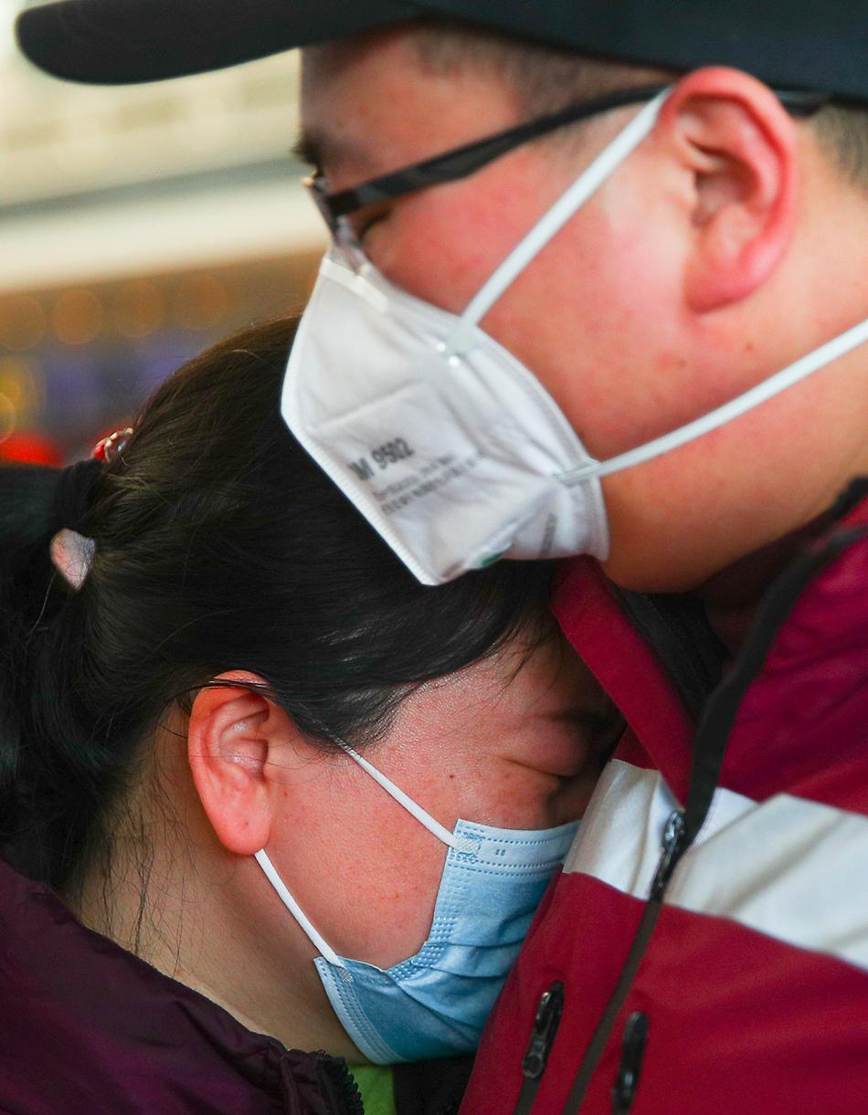 2月9日，在辽宁沈阳桃仙机场，一位医疗队队员（右）在出发前与亲人告别。