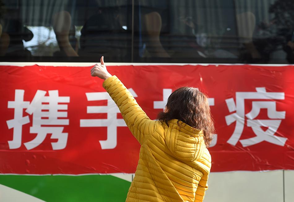 2月9日，在位于杭州的浙江省人民医院，一名前来送行的妇女向医疗队队员竖起大拇指“点赞”。