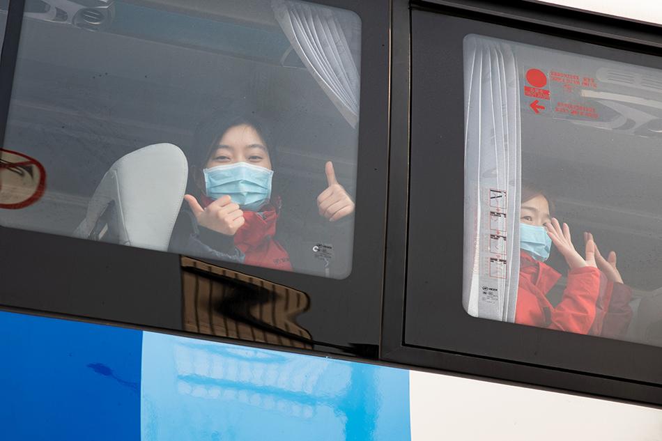 江苏省连云港市支援湖北医疗队队员在汽车上与送行的人们告别。