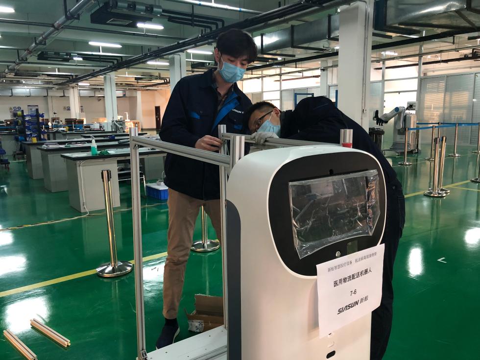 2月3日，在沈阳新松机器人自动化股份有限公司，工程师在调试医用物流配送机器人。新华社发