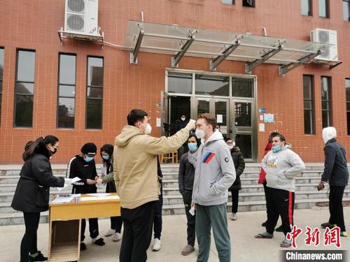 中国侨网湖南工业大学工作人员为留学生测量体温。陈芹摄