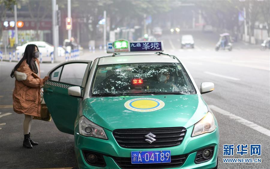 2月23日,在重庆市南川区城区街道上,一名女士正在打出租车.