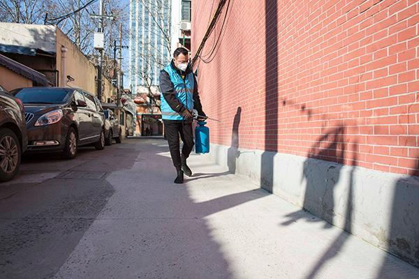 上海华阳物业工作人员陈学良在愚园路上弄堂喷洒消毒水。本文现场图片 澎湃新闻记者 伊川 图