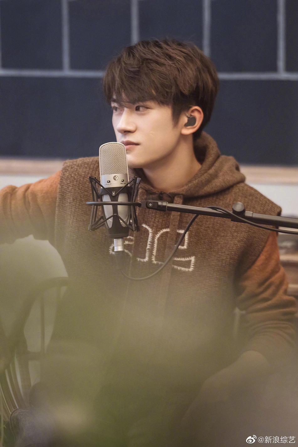 易烊千玺穿复古连帽马甲专注聆听梨涡浅笑文艺范十足