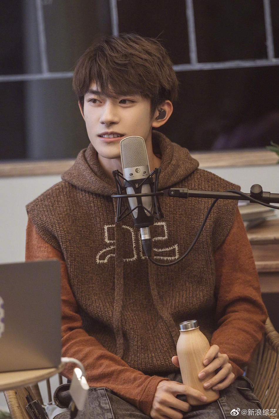 易烊千玺穿复古连帽马甲专注聆听梨涡浅笑文艺范十足