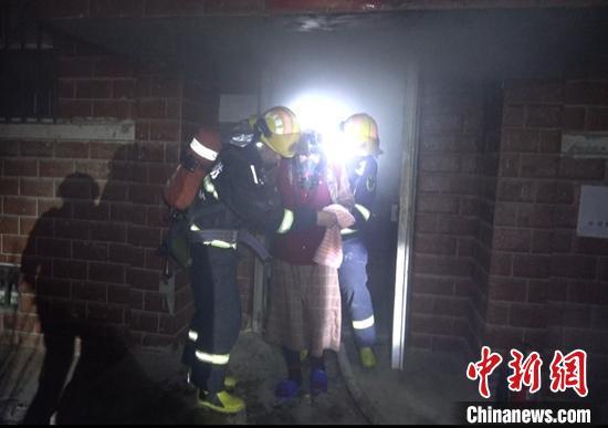 3月18日凌晨1时许,一居民楼地下室发生火灾,消防员救出被困老人。 汪渝 摄