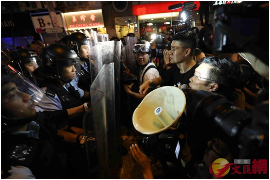 区诺轩手持扬声器阻碍警方防线推进(图片来源：香港“大公文汇全媒体”)