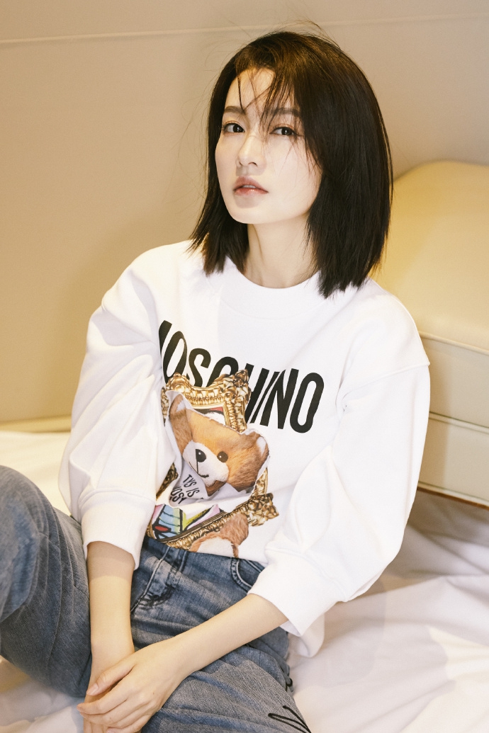 照片中的李沁留一头随性短发,身穿卡通熊上衣,搭配蓝色牛仔九分裤,对