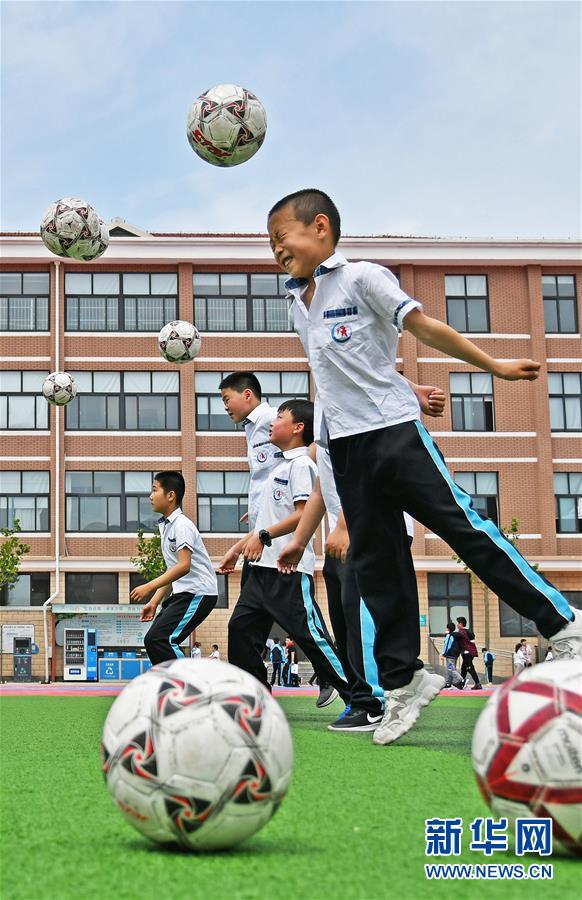 5月29日,山东省烟台市福山区东华小学学生在操场上玩足球游戏